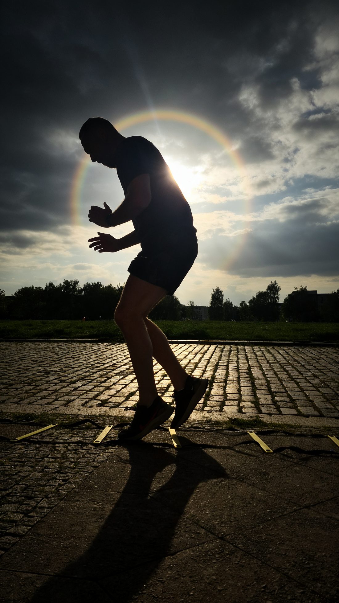 Silhouette beim Lauf-ABC an der Koordinationsleiter vor Sonnenhalo – Personal Training in Berlin
